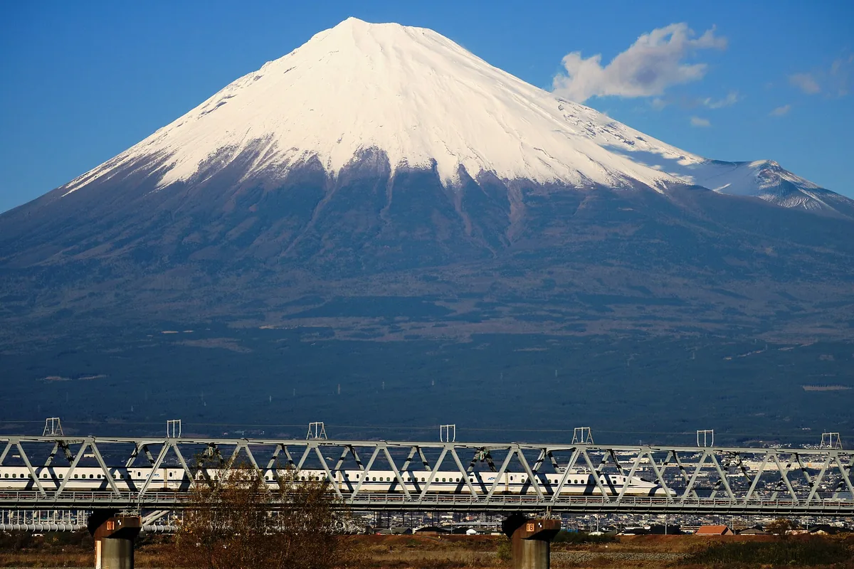 An N700 shinkansen crossing the Fujikawa bridge with Mount Fuji behind