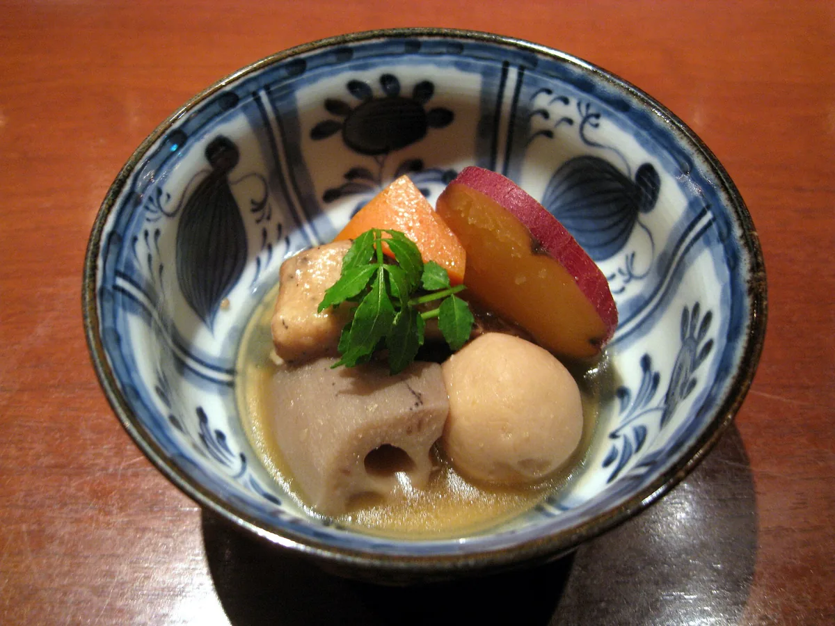 Bowls of obanzai side dishes arranged along a counter at a Kyoto izakaya