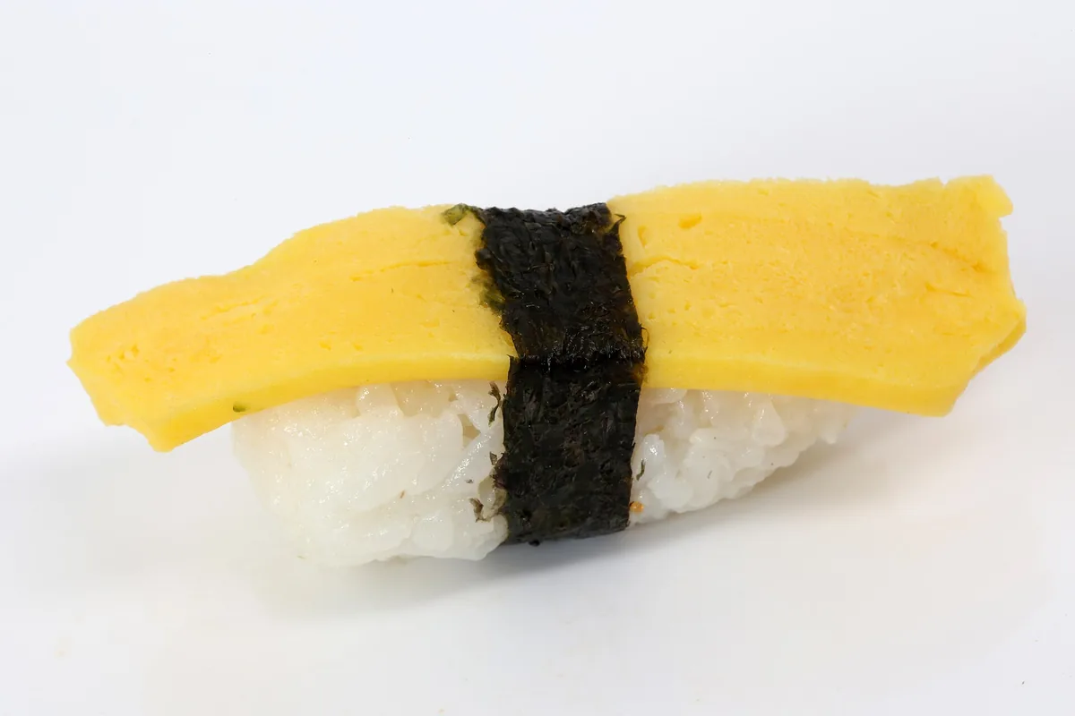 Oversized sushi pieces on a plate at a counter in Osaka