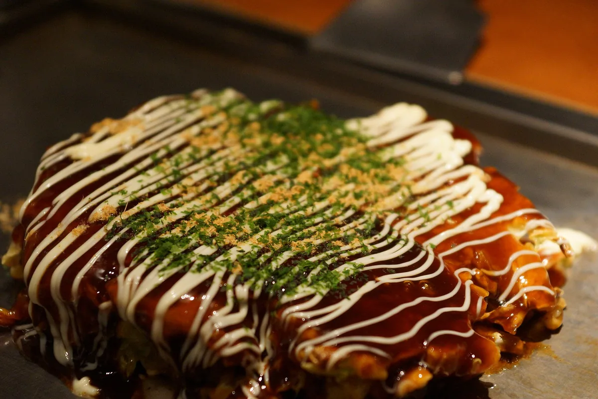 Okonomiyaki cooking on the counter griddle at Mizuno, Osaka