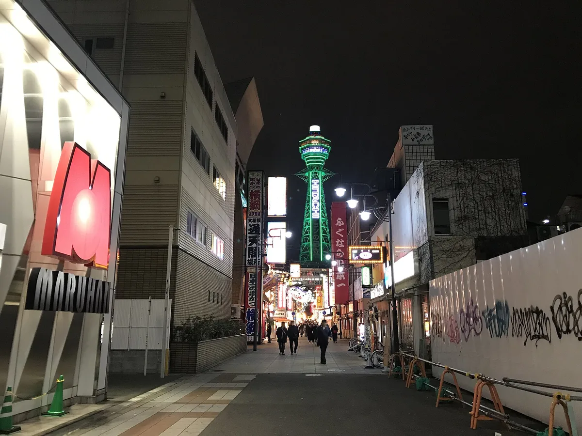 The steel tower of Tsutenkaku lit at night above Shinsekai, Osaka