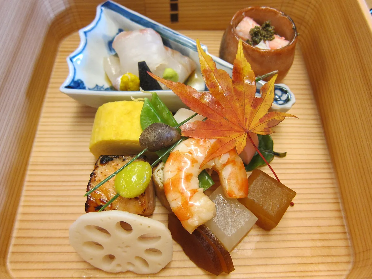 A composed Japanese course on a ceramic plate at a counter restaurant