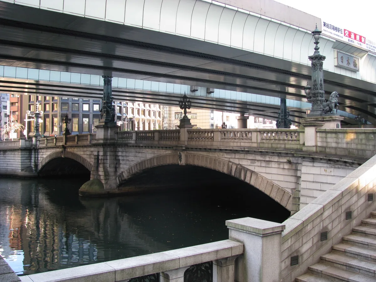 The moat and stone walls of the former Edo Castle with modern towers behind