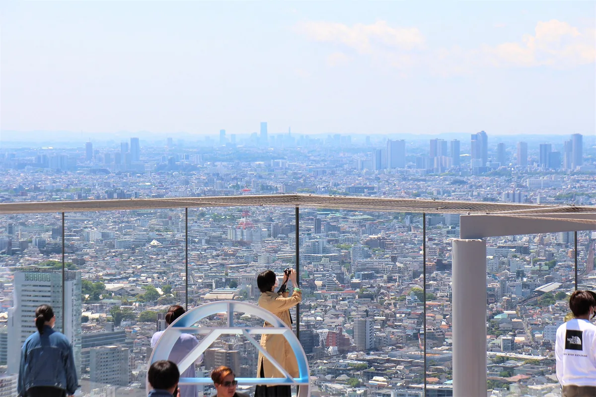 The open rooftop deck of Shibuya Sky above the Shibuya skyline at dusk