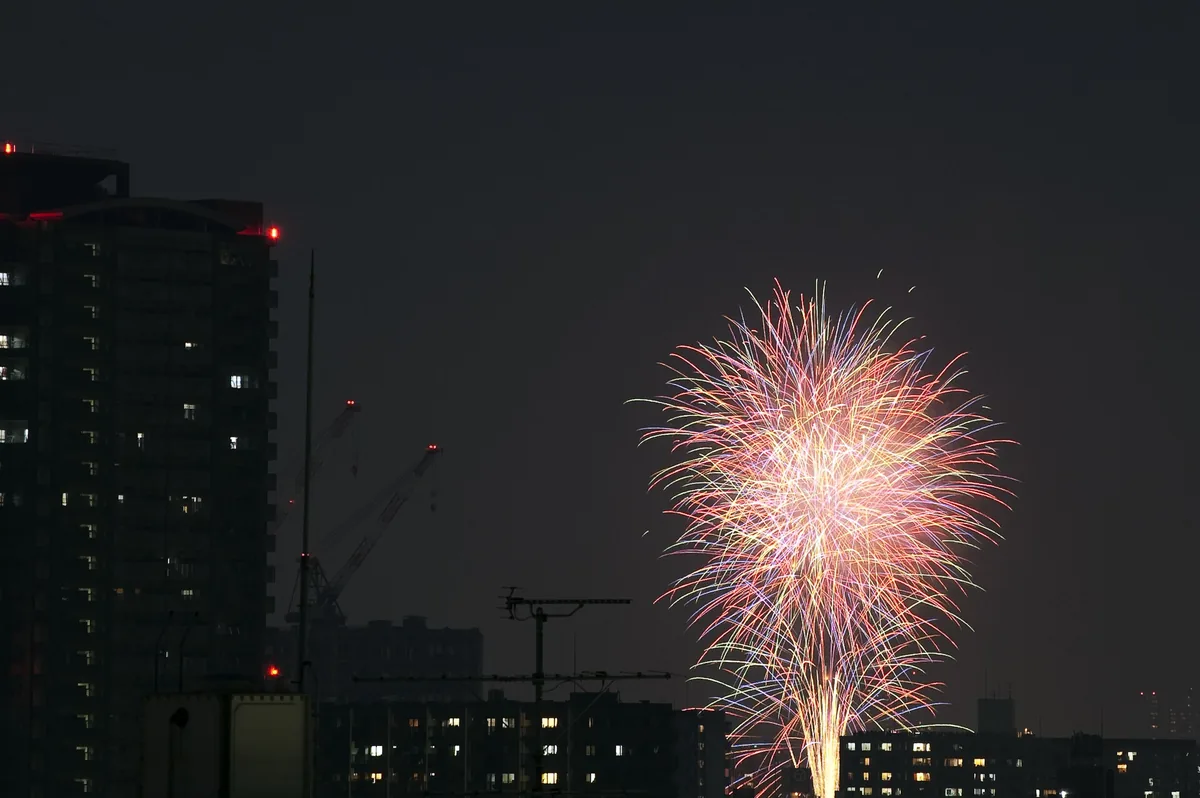 Fireworks bursting over the Sumida river with Tokyo Skytree lit behind